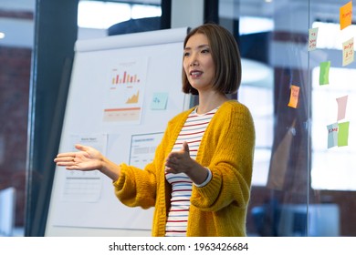 Asian businesswoman standing in front of whiteboard giving presentation in office. independent creative design business.