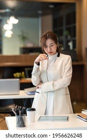 Asian Businesswoman Standing Holding Pen Thinking Concentrate On Work Tablet Place At The Office.