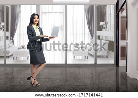 Asian businesswoman standing while using a laptop working from home. Prevent flu disease Coronavirus