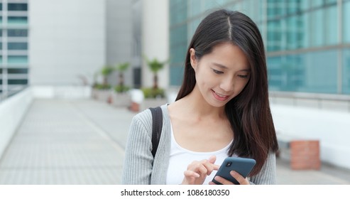 Asiatische Geschäftsfrau, die Mobiltelefone benutzt 