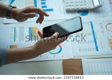 An Asian businesswoman uses a mobile phone to contact a customer to inform her of the company's business partnership.