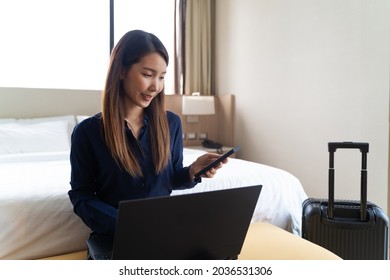 Asian Businesswoman Using Laptop Working In Hotel Room Remotely On Her Business Travel