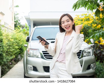 Asian Businesswoman Using Smart Phone Against A Car. Asian Woman Dealer Standing Near Car.