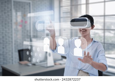 Asian businesswoman using vr virtual reality headset interacting with internet browser and video call window with an application working and entertainment system. Working in an office background. - Powered by Shutterstock