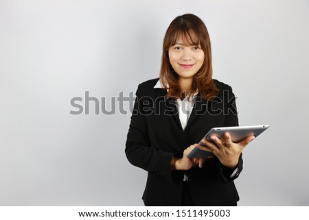 asian businesswoman wearing black business suit uniform, using tablet with smiling and confident face on white background