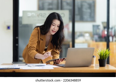 Asian businesswoman working with digital finance marketing chart at office, Accounting statistics concept.  - Shutterstock ID 2206348859