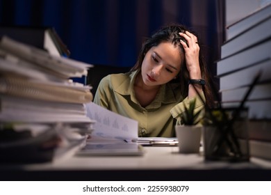 Asian businesswoman working hard late hours with a lot of document at home. She is busy and exhausted of work overtime at night. - Powered by Shutterstock