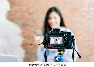 Asian Businesswoman Working From Home Live Video Interaction With Customers Using Camera Device Vlogging Selling Make Up Products, Viral Internet Social Media Influencer Interacting To Live Audience