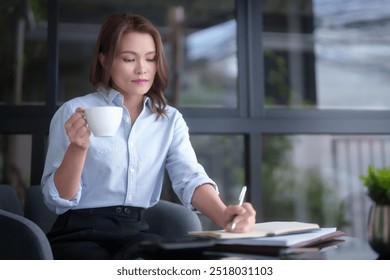 Asian businesswomen drinking coffee and checking marketing business document to taking notes in notebook while working to analyzing investment and market stock of new startup in outside office. - Powered by Shutterstock