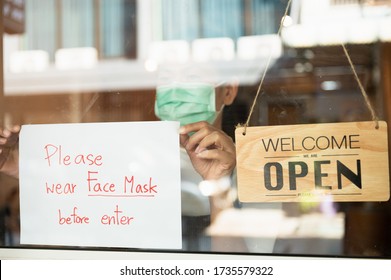 Asian Cafe Or Restaurant Shop Owner Woman Attaching Request Customer To Wear Face Mask Before Enter Cafe Sign Board At Entrance Door For Prevent Corona Virus Infection After Lock Down From Pandemic.