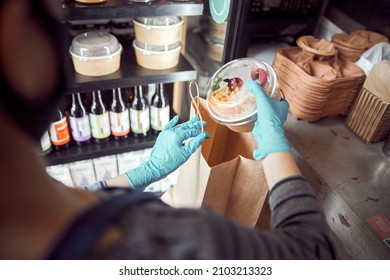 Asian Cafe Worker Preparing Takeout Meal Indoors