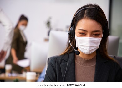 Asian call center with mask  for hygiene in their office.Cantact service support with headset phone.Assistance Thai support contact. - Powered by Shutterstock