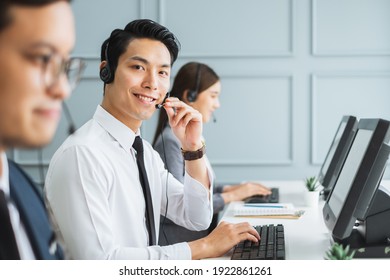 Asian call center team, customer service, telesales in formal suit wearing headset or headphone talking with customer in modern office - Powered by Shutterstock