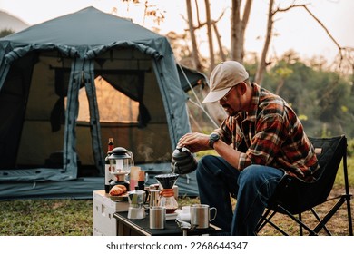 Asian camper, A man drip coffee in the camp, A man pouring water on coffee ground with filter.Drip coffee and camping. - Powered by Shutterstock