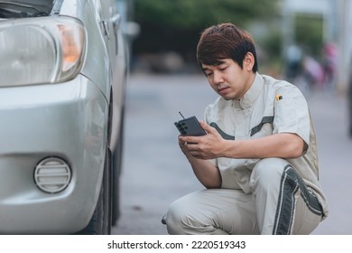 Asian Car Mechanic Technician Sitting And Checking Car Tyres Or Car Wheel In In Auto Repair Shop Garage. Wheel Tire Repair Service.