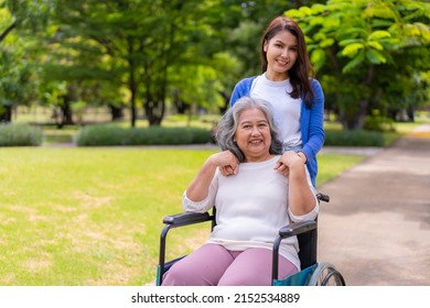 Asian Careful Caregiver Or Nurse Taking Care Of The Patient In A Wheelchair.  Concept Of Happy Retirement With Care From A Caregiver And Savings And Senior Health Insurance, A Happy Family