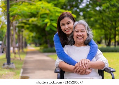 Asian Careful Caregiver Or Nurse Taking Care Of The Patient In A Wheelchair.  Concept Of Happy Retirement With Care From A Caregiver And Savings And Senior Health Insurance, A Happy Family