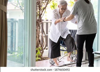 Asian Caregiver Help Care To Senior Grandmother Walk,woman Holding Hands Of The Old Elderly For Support,walking Up From A Different Level Floor,safety,prevent Accident At Nursing Home,service Concept