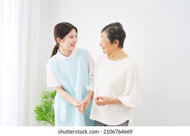 Asian Caregiver And A Senior Woman At The Room