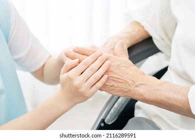 Asian Caregiver Touching A Senior Woman Hand, No Face