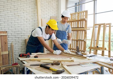 An Asian carpenter is drawing a line on a piece of wood, preparing to cut into sections. The other man told the size he wanted by looking at his note. Morning work atmosphere in the workshop room. - Powered by Shutterstock - Get 15% off with code: PIKWIZARD15