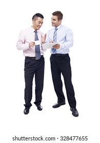 Asian And Caucasian Business Men Having A Discussion With Coffee Cup And Tablet Computer In Hands, Isolated On White Background.