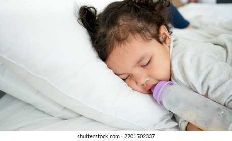 Asian caucasian cute baby girl sleeping on the bedroom background.Cute little baby with bottle lying in comfortable crib. Bedtime.baby girl, asleep with milk bottle.