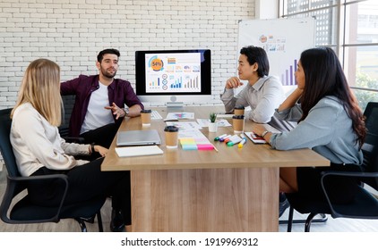 Asian And Caucasian Group Of Happy Young Business People In A Meeting At Office. Business Meeting Working Together With Colleagues In The Modern. Concept Meeting Cozy Smile Graph