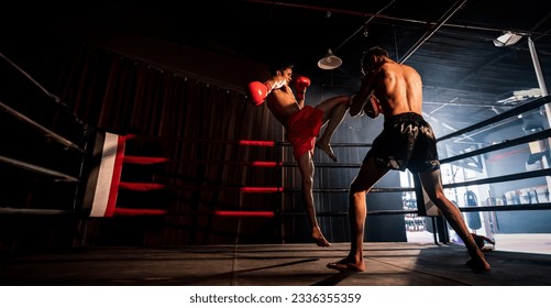 El boxeador asiático y caucásico Muay Thai desató un ataque de rodilla en una feroz sesión de entrenamiento de boxeo, entregando un ataque de rodilla al entrenador, mostrando técnica y habilidad de boxeo Muay Thai. Spur