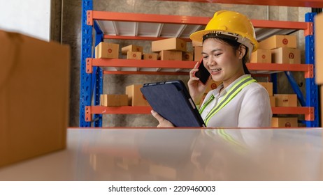 Asian Caucasian Woman Warehouse Worker Checking Parcel Using Tablet In Large Distribution Center, Delivery Concept.