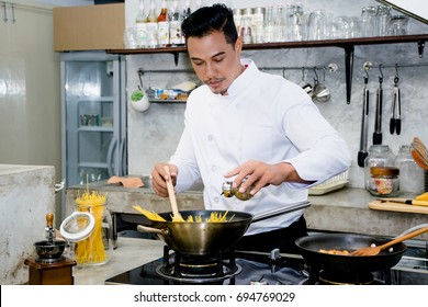 Asian Chef Is Cooking Food By Using Wooden Ladle At The Kitchen Of A Restaurant