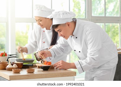 Asian Chefs Cooking Together In Kitchen