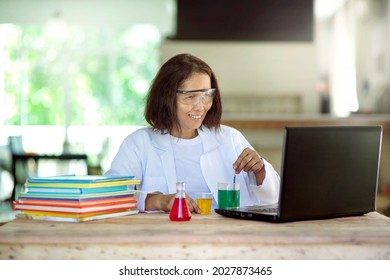 Asian Chemistry Teacher Online Lesson.Lab Experiment Lecturer Showing Chemical In Beaker.Female Person Holding Laboratory Glassware With Liquid.Science Remote Learning From Home.Scientific Experiment.