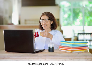 Asian Chemistry Teacher Online Lesson.Lab Experiment Lecturer Showing Chemical In Beaker.Female Person Holding Laboratory Glassware With Liquid.Science Remote Learning From Home.Scientific Experiment.