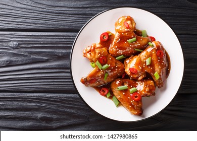 Asian Chicken Wings In Teriyaki Sauce Close-up On A Plate On The Table. Horizontal Top View From Above
