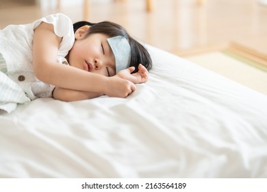 Asian child in bed with fever - Shutterstock ID 2163564189