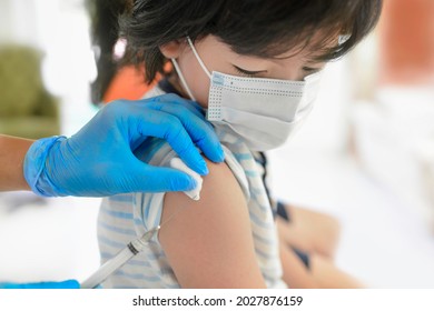 Asian Child Being Vaccinated.Children Vaccination By Nurse.Medical Doctor Vaccinating School Student In The Arm.Paediatrician Administrating Vaccine To Students In Clinic.Physician Injecting Person.