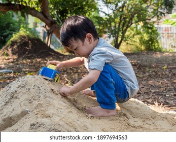 Asian Child Boy Playing Car Toy On Sand Outdoor With Cute Face In Nature Background. Happy Kid Enjoy In Relaxing Day, Preschool Learning Ef, Family Activity In Summer, Freedom Concept.  