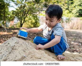 Asian Child Boy Playing Car Toy On Sand Outdoor With Cute Face In Nature Background. Happy Kid Enjoy In Relaxing Day, Preschool Learning Ef, Family Activity In Summer, Freedom Concept.  