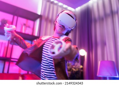 Asian child boy wear VR or virtual reality glasses,headsets standing and playing a video game at living room in front of TV at home in quarantine period technology and innovation concept neon light  - Powered by Shutterstock