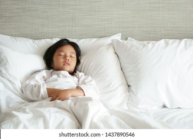 Asian Child Cute Or Kid Girl Wear Pajamas Sleeping Well With Comfortably And Sweet Dream For Relax On White Bed And Pillow With Blanket In Bedroom At Home With Morning Light And Wake Up Late