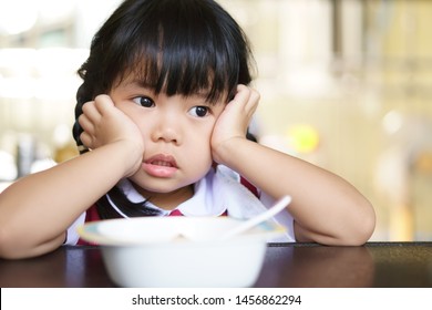 Asian Child Cute Or Kid Girl Student Anorexia Or Bored With Food And Sad Vacant With Prop Up Or Hand To Cheek On Food Table For Breakfast Before Going To Kindergarten Preschool For Summer Study