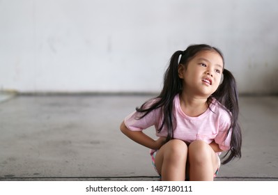 Asian Child Cute Or Kid Girl Sit Stomachache And Sick From Bacteria And Gastritis With Diarrhea Or Hungry With Holding Hand In Stomach On Street With Space