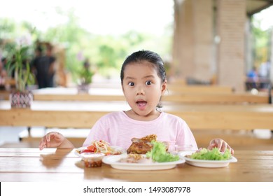 Asian Child Cute Or Kid Girl Wow And Surprise With Enjoy Eating Grilled Chicken And Papaya Salad For Thai Food And Appetizing On Table And Happy For Breakfast Or Lunch In Restaurant Or Food Court