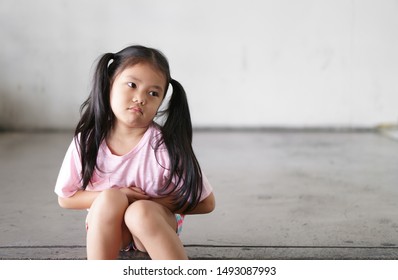 Asian Child Cute Or Kid Girl Sit Stomachache And Sick From Bacteria And Gastritis With Diarrhea Or Hungry With Holding Hand In Stomach To Frown And Poor On Street With Space