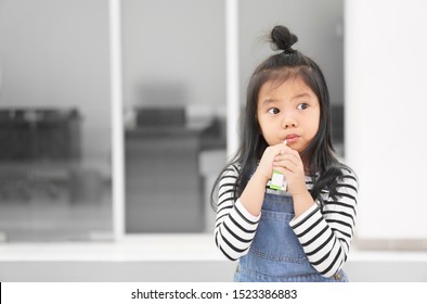 Asian Child Cute Or Kid Girl Enjoy Drinking Box Milk Or Curd And Soy Milk Beverage For Protein By Tube Or Straw To Thirsty Water For Delicious Dessert And Healthy At Kindergarten Nursery Or School