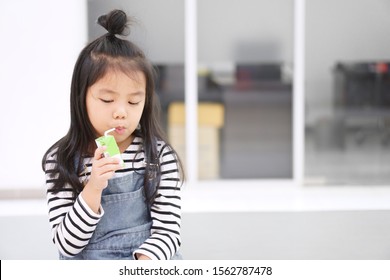 Asian Child Cute Or Kid Girl Enjoy Drinking Box Milk Or Curd And Soy Milk Beverage For Protein By Tube Or Straw To Thirsty Water For Delicious Dessert And Healthy At Kindergarten Nursery Or School