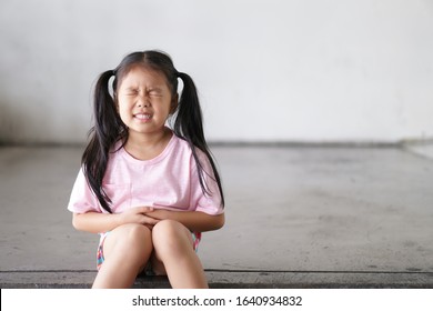 Asian Child Cute Or Kid Girl Sit Stomachache And Sick From Bacteria Or Dirty Disease And Gastritis With Diarrhea Or Hungry With Holding Hand In Stomach To Frown And Poor On Street With Space