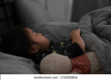 Asian Child Cute Or Kid Girl Sleeping Well With Comfortably And Sweet Dream At Night For Relax On Gray Dark Bed And Pillow Blanket With Teddy Bear Doll In Bedroom At Home And Morning To Wake Up Late