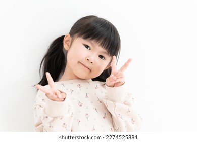 Asian child doing V-sign on white background